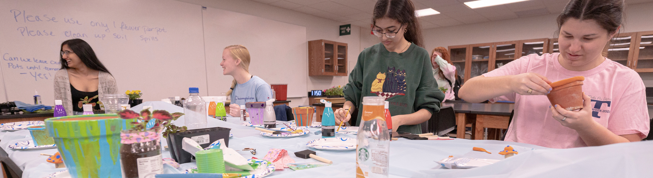 four students crafting unique flower pots