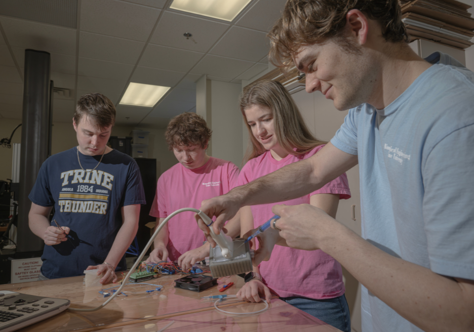 four students work on central line trainer updates