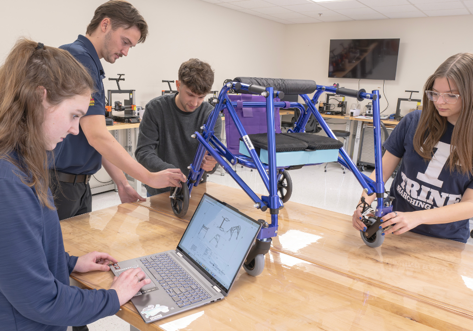 four students work on a pediatric walker