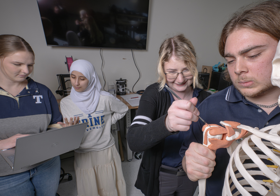 four students work on redesigning a shoulder replacement instrument