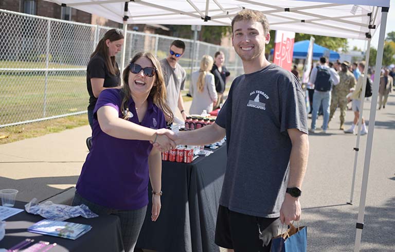 Student and employment recruiter shaking hands