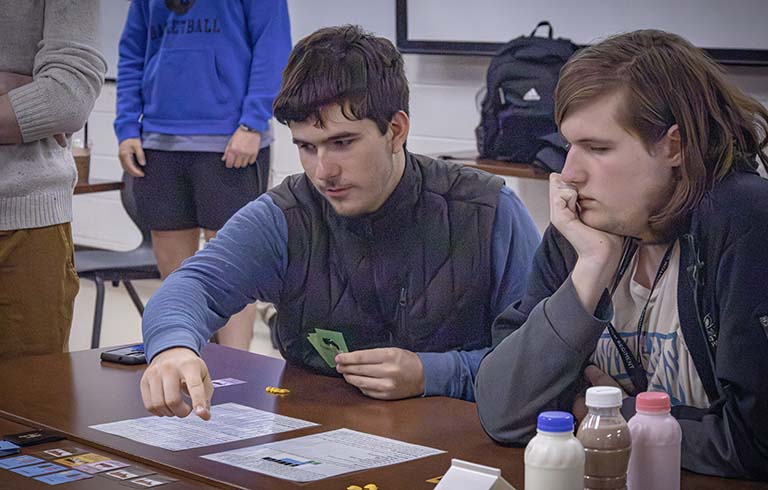 Two Trine students playing board game
