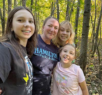 Mom and three daughters foraging in the woods