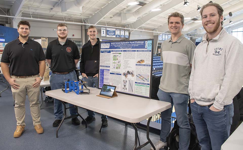 Trine University design engineering students with research poster