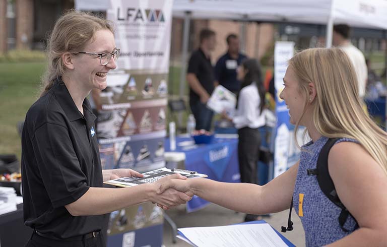 Student and hiring professional shaking hands