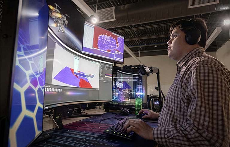 Trine University student working with artificial intelligence on computers
