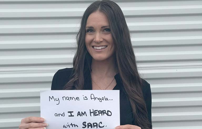 Angela Kesler Santoro holding sign for SAAC advocacy