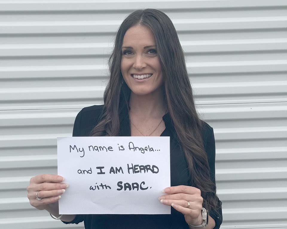 Angela Kesler Santoro with SAAC sign