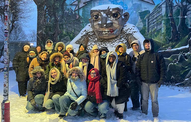 Students in front of sculpture in Christiania, Denmark.