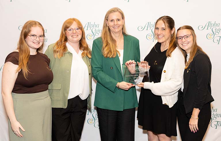 Four sorority officers receiving award from national president