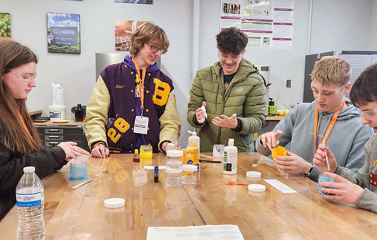 High school students at table with lab equipment