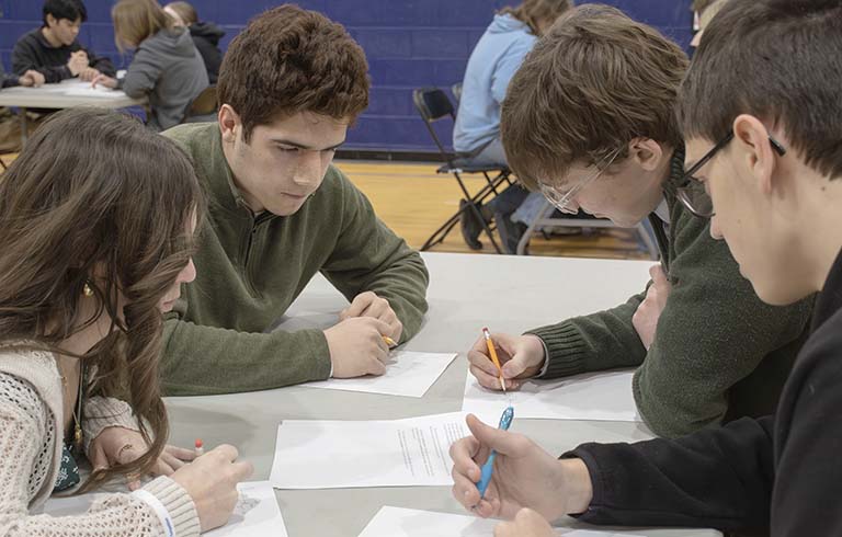 Four students working on math problems