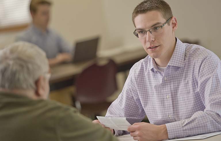 Trine University working with client at VITA income tax preparation