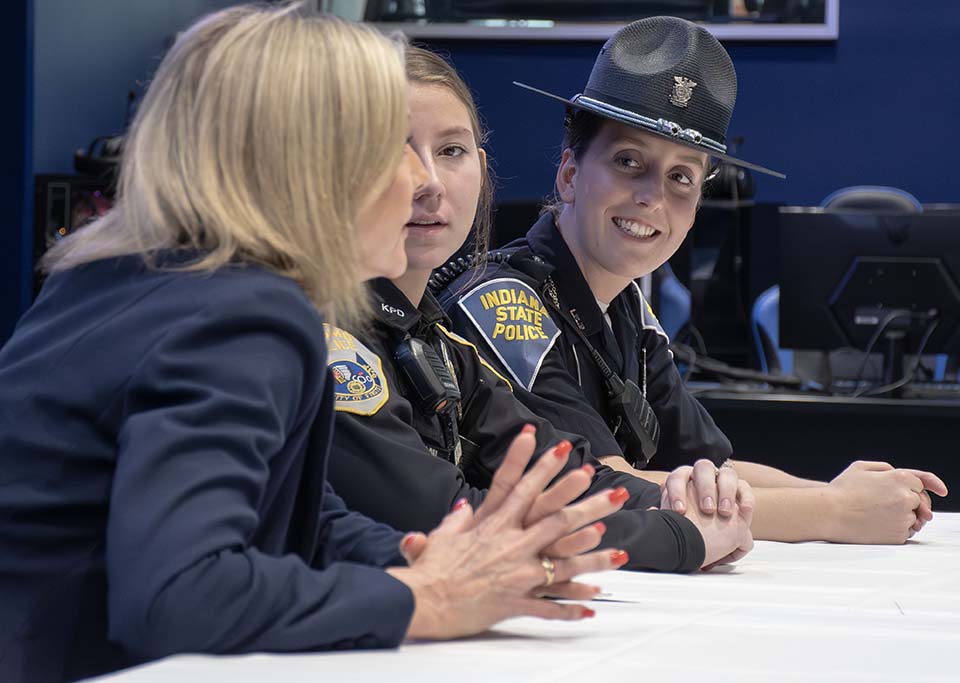 Three women who work in criminal justice speaking while seated at a table